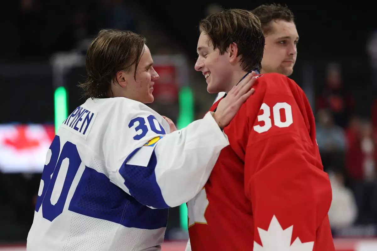 Finland goalie Petteri Rimpinen, left, greets Canada goalie Carter George after an IIHF World Junior Hockey Championship bronze medal game, Monday, Jan. 5, 2026, in St. Paul, Minn. (AP Photo/Matt Krohn)