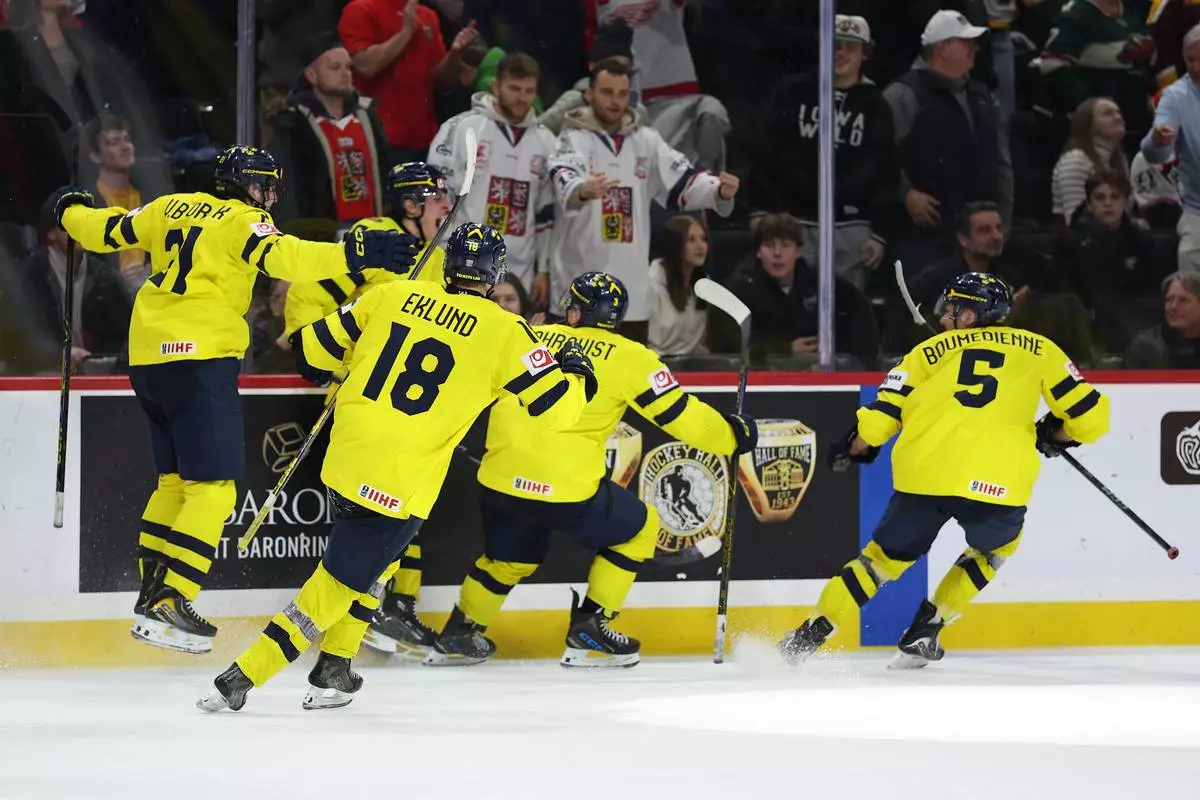Sweden's Ivar Stenberg (15) celebrates with teammates after scoring a goal during the third period of an IIHF World Junior Hockey Championship gold medal game against Czechia, Monday, Jan. 5, 2026, in St. Paul, Minn. (AP Photo/Matt Krohn)