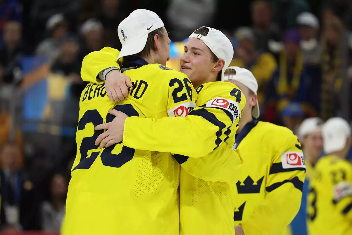Sweden Jack Berglund (26) and Leo Sahlin Wallenius (4) celebrate after winning an IIHF World Junior Hockey Championship gold medal game against Czechia, Monday, Jan. 5, 2026, in St. Paul, Minn. (AP Photo/Matt Krohn)