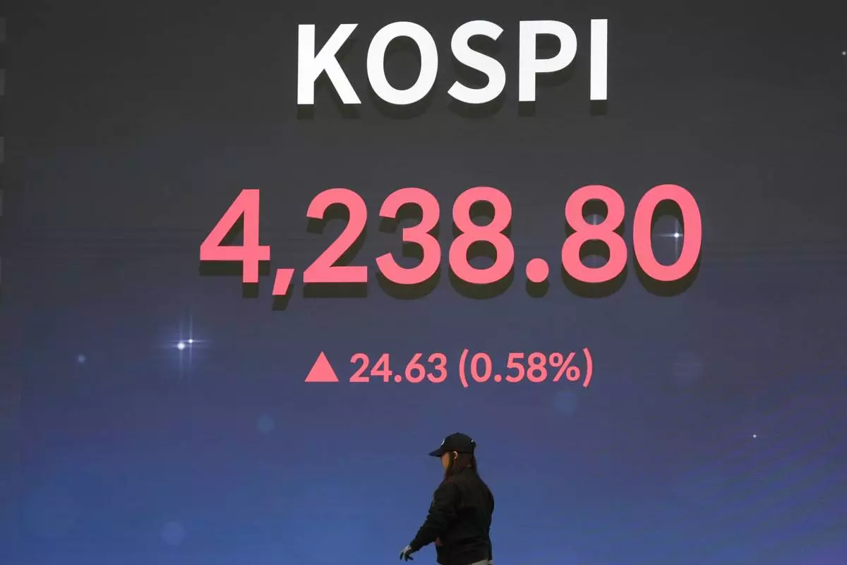 A worker walks near a screen showing the Korea Composite Stock Price Index (KOSPI) after the opening ceremony of the 2026 trading year at the Korea Exchange in Seoul, South Korea, Friday, Jan. 2, 2026. (AP Photo/Lee Jin-man)