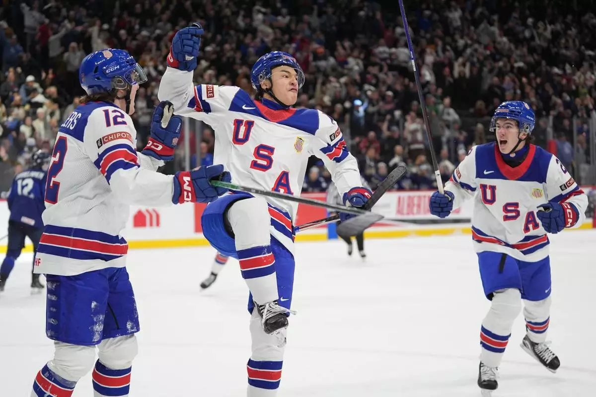 United States forward Ryker Lee, center, celebrates after scoring a goal during the third period of an IIHF World Junior Hockey Championship quarterfinals game against Finland, Friday, Jan. 2, 2026, in St. Paul, Minn. (AP Photo/Abbie Parr)