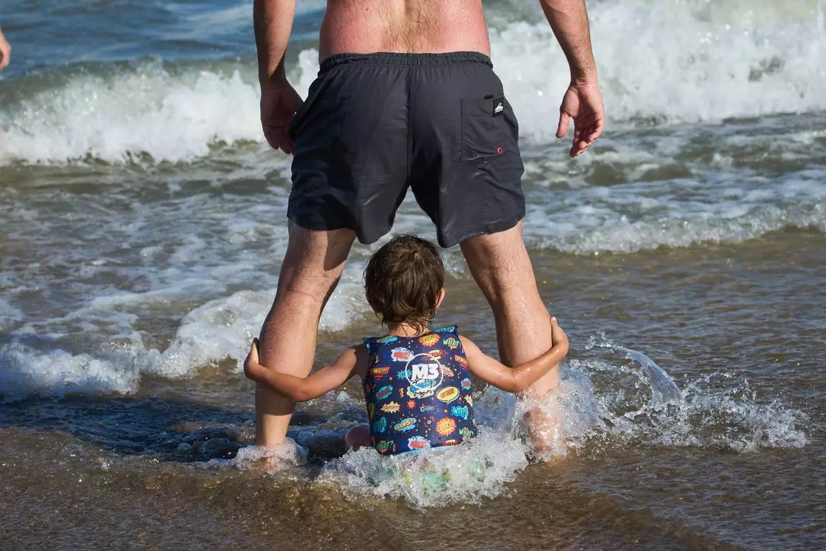 FILE - People spend time on the beach in Carilo, Buenos Aires province, Argentina, Dec. 28, 2025. (AP Photo/Rodrigo Abd, File)