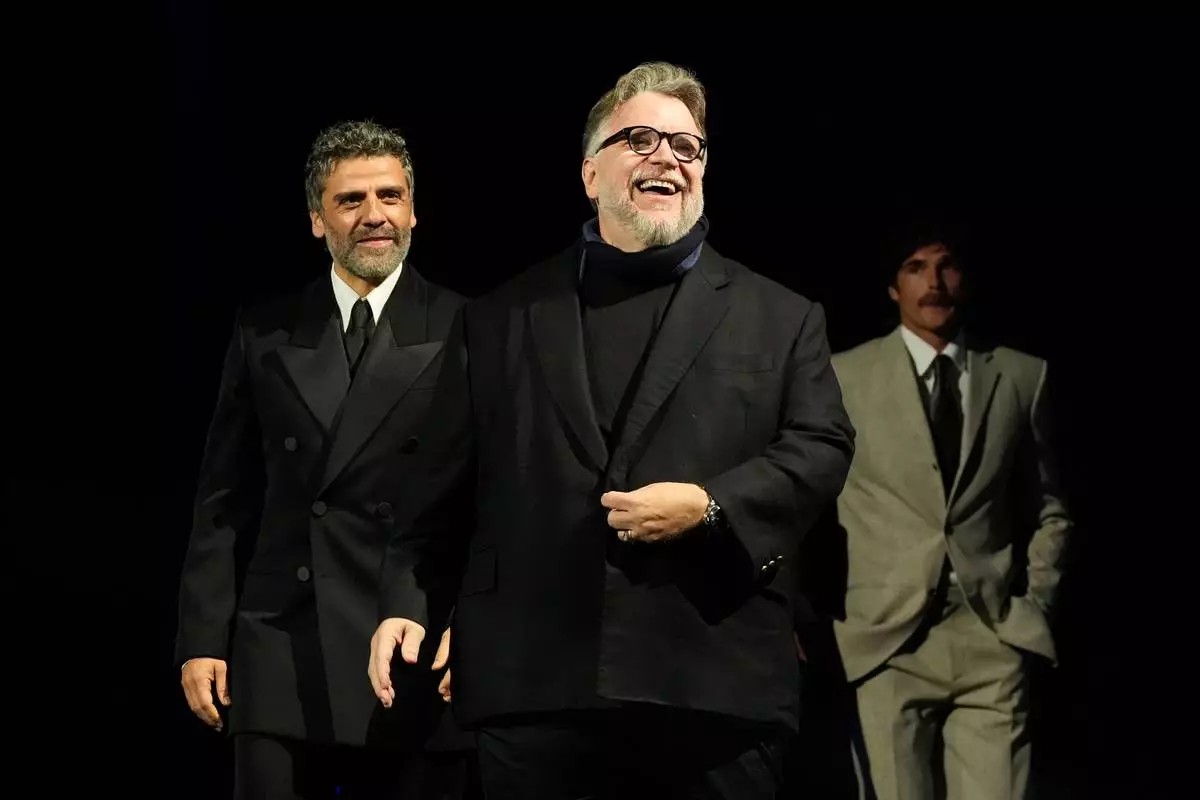 CORRECTS SPELLING OF PERSON SHOWN - Oscar Isaac, from left, Guillermo del Toro, and Jacob Elordi walk onstage during the 37th Palm Springs International Film Festival Film Awards on Saturday, Jan. 3, 2026 at Palm Springs Convention Center in Palm Springs, Calif. (AP Photo/Chris Pizzello)