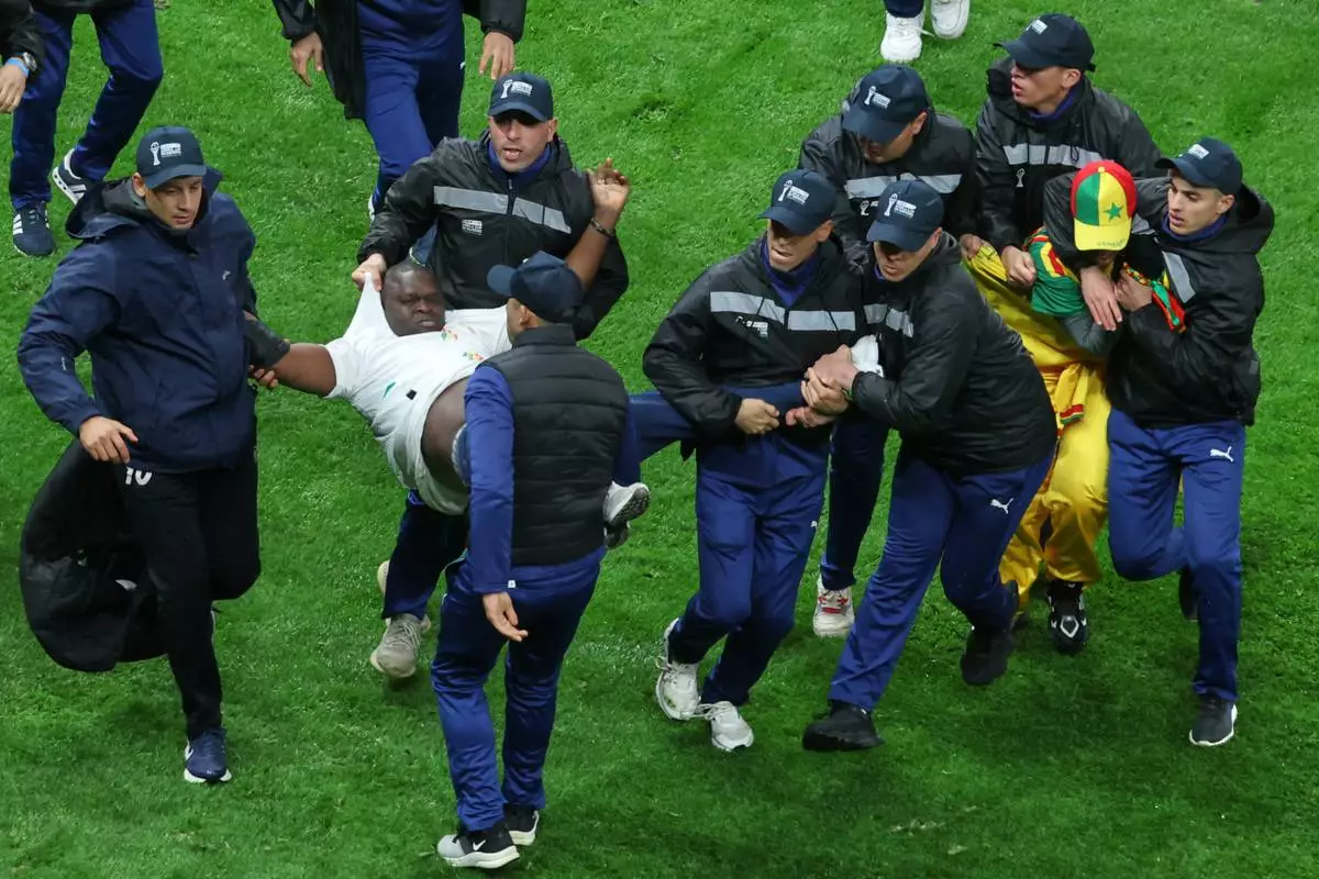 Senegal supporters are taken from the stadium by security officers after a controversial penalty was awarded to Morocco late on during the Africa Cup of Nations final soccer match between Senegal and Morocco in Rabat, Morocco, Sunday, Jan. 18, 2026. (AP Photo/Youssef Loulidi)