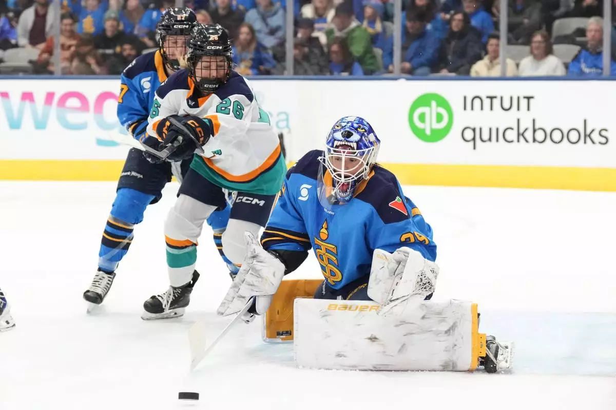 Toronto Sceptres goaltender Elaine Chuli makes a stop as New York Sirens' Casey O'Brien closes in during the first period of an PWHL hockey game, in Toronto, Tuesday Jan. 6, 2026. (Chris Young/The Canadian Press via AP)