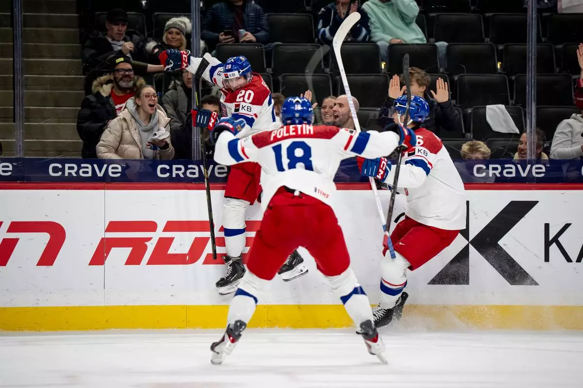 Czechia's Adam Benak celebrates his goal with teammates Tomas Poletin (18) and Radim Mrtka during the second period of an IIHF World Junior Hockey Championship semifinals game, Sunday, Jan. 4, 2026, in St. Paul, Minn. (Christopher Katsarov/The Canadian Press via AP)