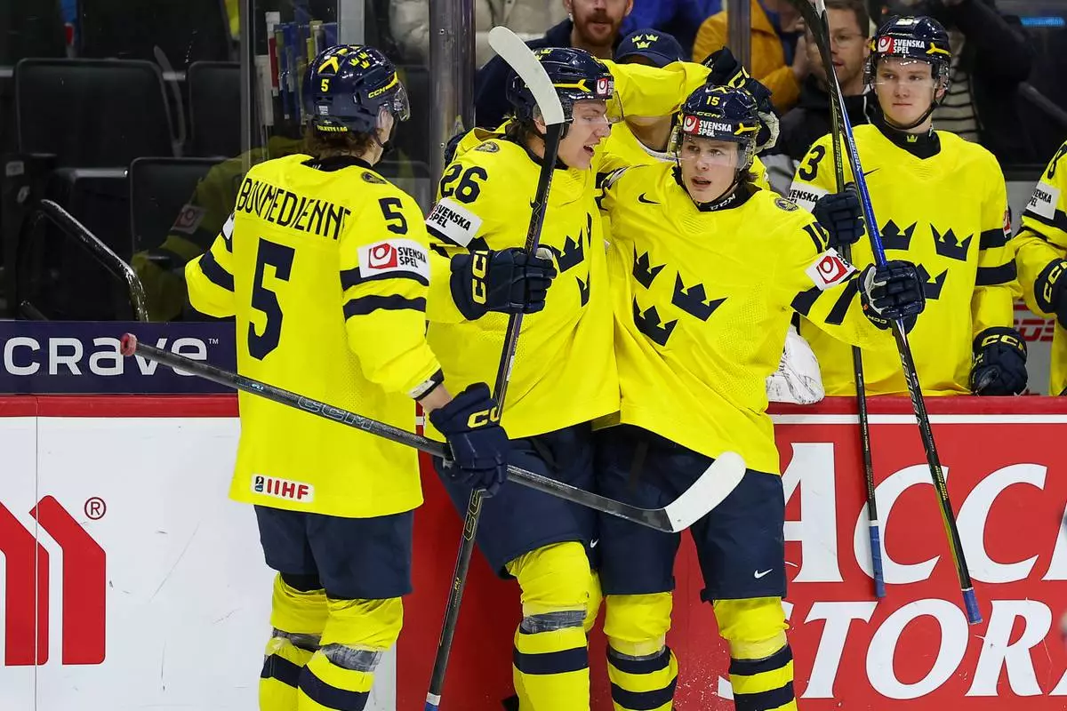 Sweden forward Ivar Stenberg, right, celebrates his goal with teammates during the second period of an IIHF World Junior Hockey Championship semifinals game against Finland, Sunday, Jan. 4, 2026, in St. Paul, Minn. (AP Photo/Matt Krohn)