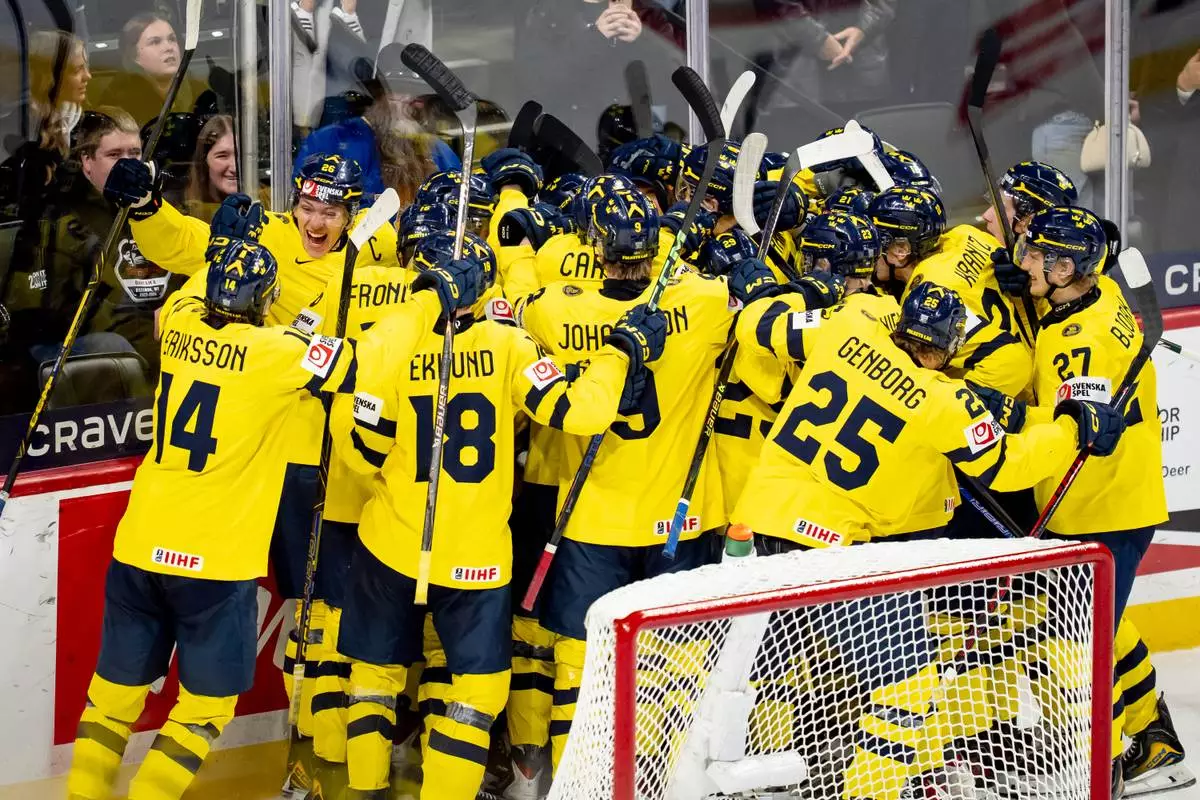 Team Sweden players celebrate after Anton Frondell scored on Finland goaltender Petteri Rimpinen (30) during overtime shoot-out in an IIHF World Junior Hockey Championship semifinals game in St. Paul, Minn., Sunday, Jan. 4, 2026. (Christopher Katsarov/The Canadian Press via AP)