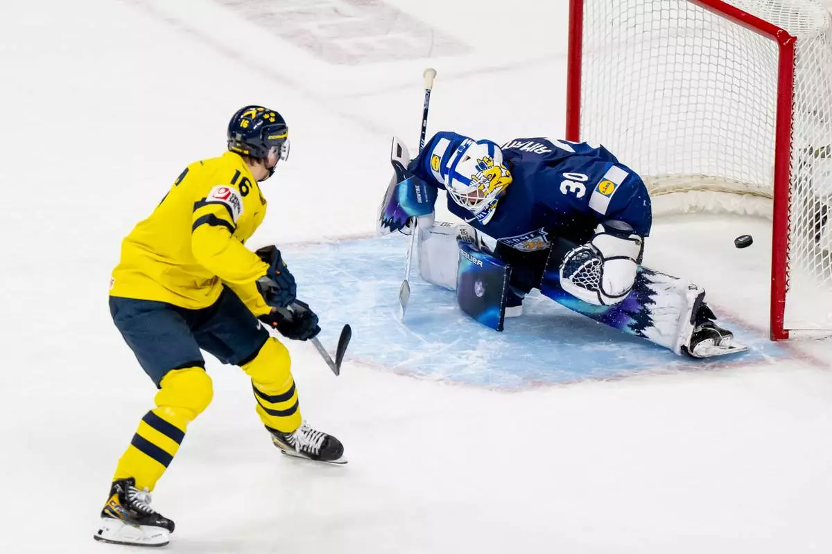 Sweden's Anton Frondell (16) scores on Finland goaltender Petteri Rimpinen during overtime shoot-out in an IIHF World Junior Hockey Championship semifinals game in St. Paul, Minn., Sunday, Jan. 4, 2026. (Christopher Katsarov/The Canadian Press via AP)