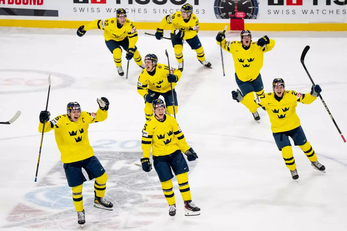 Team Sweden players celebrate after Anton Frondell scored on Finland goaltender Petteri Rimpinen during overtime shoot-out in an IIHF World Junior Hockey Championship semifinals game in St. Paul, Minn., Sunday, Jan. 4, 2026. (Christopher Katsarov/The Canadian Press via AP)