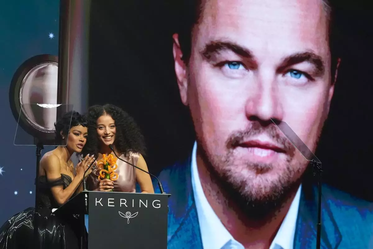 Teyana Taylor, left, and Chase Infiniti accept the desert palm achievement award on behlaf of Leonardo DiCaprio during the 37th Palm Springs International Film Festival Film Awards on Saturday, Jan. 3, 2026 at Palm Springs Convention Center in Palm Springs, Calif. (AP Photo/Chris Pizzello)