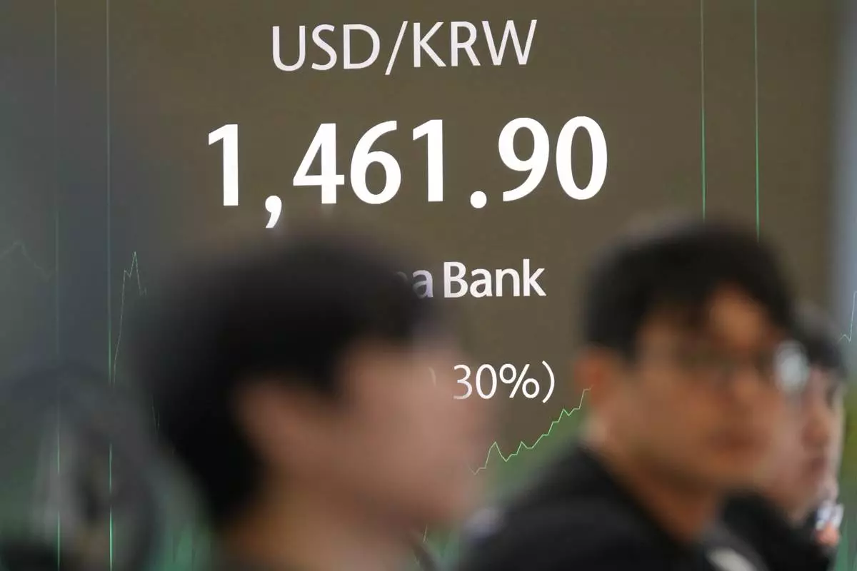 Dealers watch computer monitors near the screens showing the foreign exchange rate between U.S. dollar and South Korean won at a dealing room of Hana Bank in Seoul, South Korea, Monday, Jan. 12, 2026. (AP Photo/Lee Jin-man)