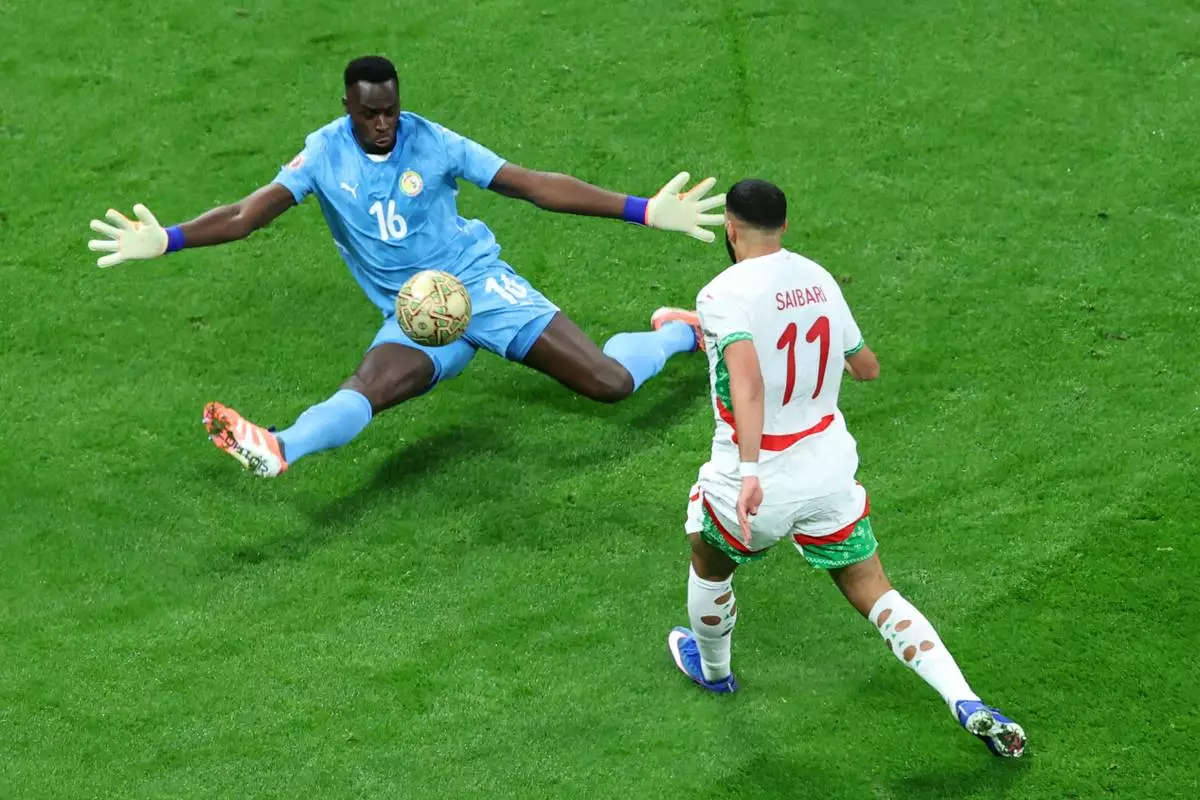 Senegal's goalkeeper Edouard Osoque Mendy saves from Morocco's Ismael Saibari during the Africa Cup of Nations final soccer match between Senegal and Morocco in Rabat, Morocco, Sunday, Jan. 18, 2026. (AP Photo/Youssef Loulidi)