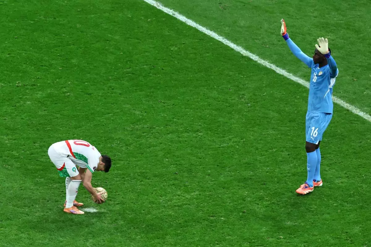 Senegal's goalkeeper Edouard Osoque Mendy, right, approaches Morocco's Brahim Abdelkader Díaz before he took a penalty during the Africa Cup of Nations final soccer match between Senegal and Morocco in Rabat, Morocco, Sunday, Jan. 18, 2026. (AP Photo/Youssef Loulidi)