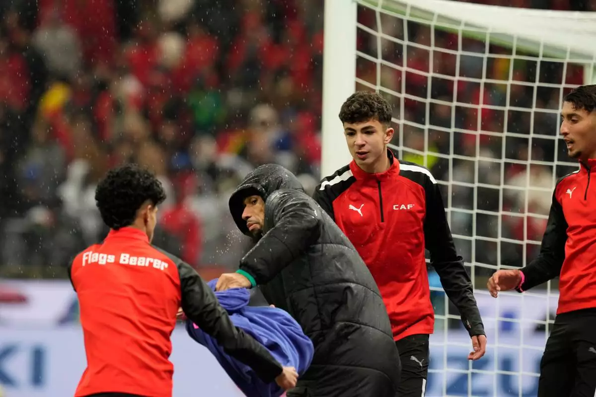 A ball boy attempts to grab a towel from Senegal's second-choice goalkeeper Yéhvann Diouf as he holds it for Senegal's goalkeeper Edouard Mendy, during the Africa Cup of Nations final soccer match between Senegal and Morocco, in Rabat, Morocco, Sunday, Jan. 18, 2026. (AP Photo/Mosa'ab Elshamy)