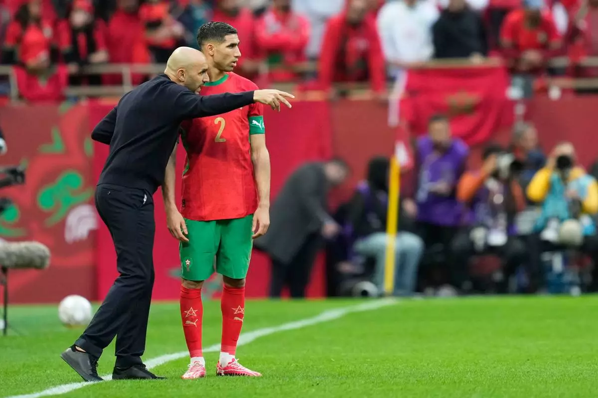 Morocco's Achraf Hakimi listens to head coach Walid Regragui during the Africa Cup of Nations round of 16 soccer match between Morocco and Tanzania in Rabat, Morocco, Sunday, Jan. 4, 2026. (AP Photo/Mosa'ab Elshamy)