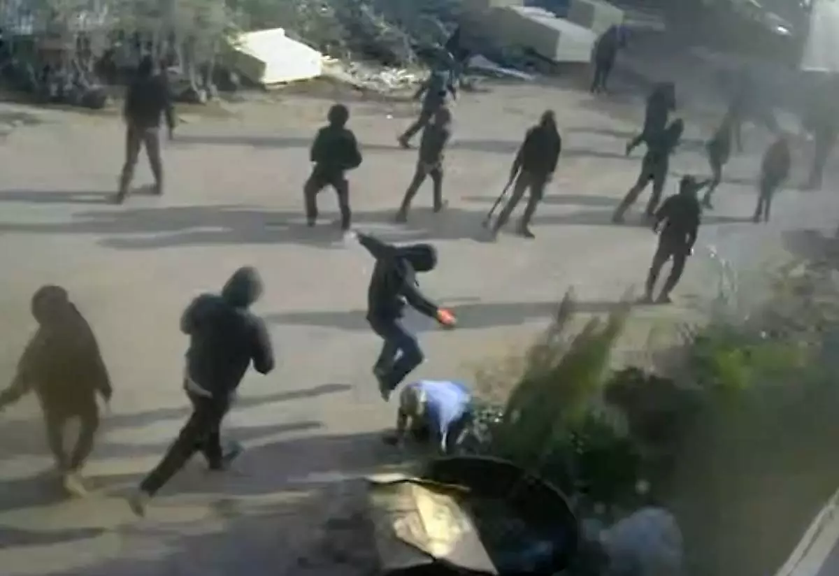 This frame grab from security camera footage filmed Jan. 8, 2026, and obtained by The Associated Press, shows men dressed mostly in black with their faces covered, one of whom is kicking a man on the ground as he tried to flee a nursery in the northern West Bank village of Deir Sharaf. Two people who witnessed the attack and are members of the family that owns the facility said the assailants were Israeli settlers beating 67-year-old Basim Saleh Yassin.(UGC via AP)