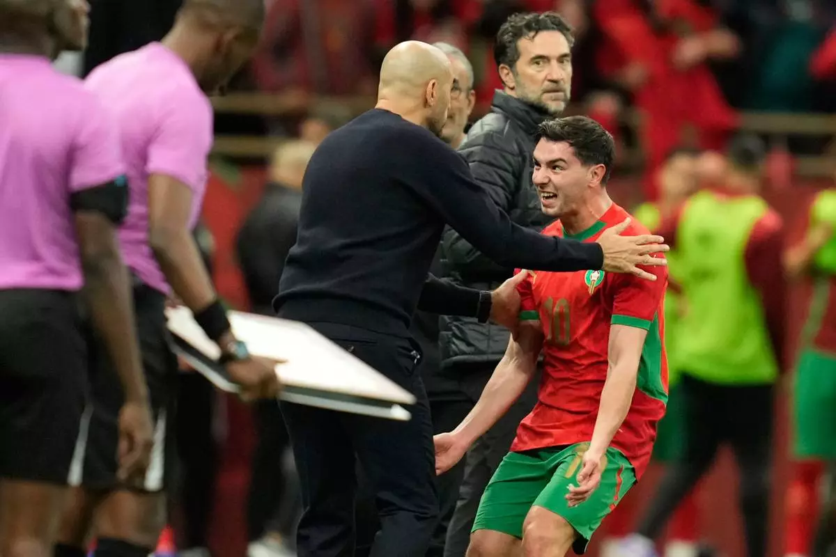 Morocco's Brahim Abdelkader Diaz celebrates with head coach Walid Regragui after scoring the opening goal during the Africa Cup of Nations round of 16 soccer match between Morocco and Tanzania in Rabat, Morocco, Sunday, Jan. 4, 2026. (AP Photo/Mosa'ab Elshamy)