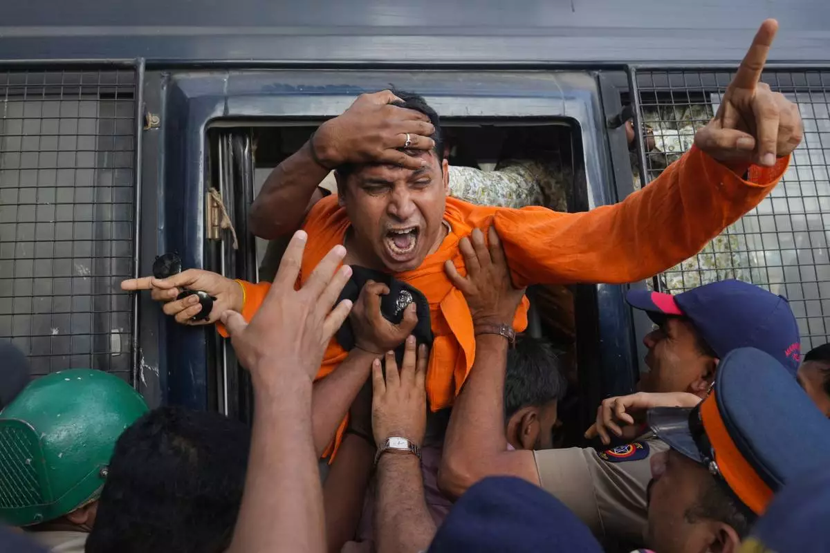 FILE - An activist from the Vishwa Hindu Parishad, a right-wing Hindu nationalist organization, shouts slogans as police detain him during a protest near the Deputy High Commission of Bangladesh, alleging that Bangladeshi groups are wrongly targeting Indians, in Mumbai, India, Dec. 23, 2025.(AP Photo/Rafiq Maqbool, File)