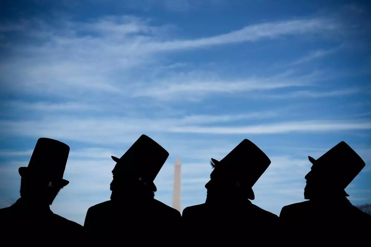 FILE - Men dressed as former President Abraham Lincoln attend a mock funeral for the penny, which was discontinued earlier in the year, in front of the Lincoln Memorial in Washington, Dec. 20, 2025. (AP Photo/Julia Demaree Nikhinson, File)