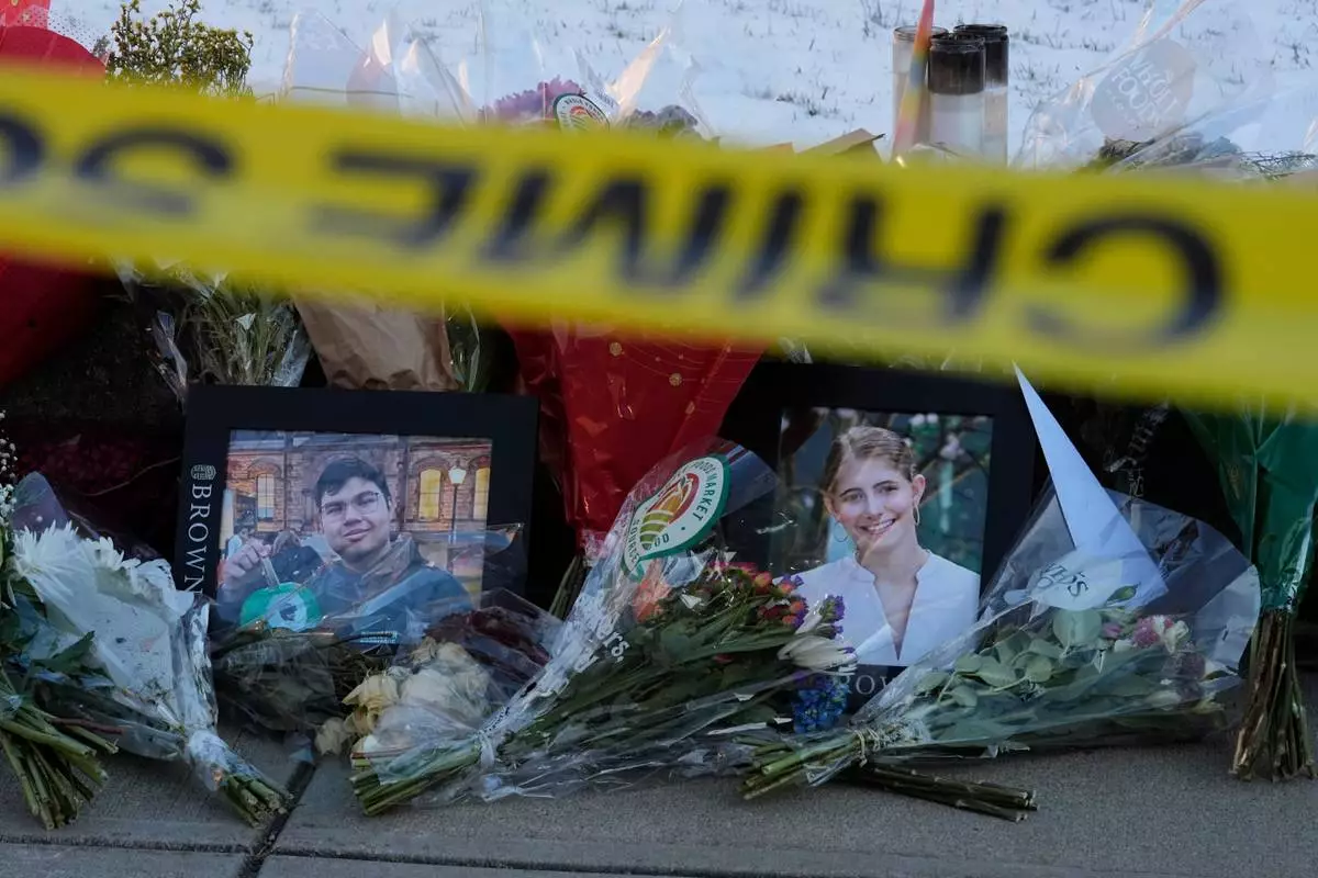 FILE - Photos of Brown University shooting victims MukhammadAziz Umurzokov, left, and Ella Cook, lay on a makeshift memorial outside the Engineering Research Center, Dec. 16, 2025, in Providence, R.I. (AP Photo/Robert F. Bukaty, File)