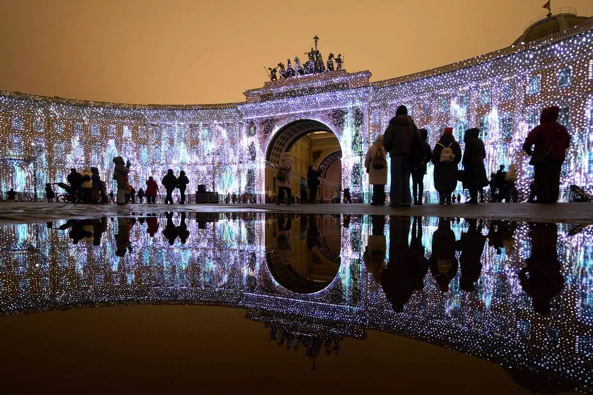 FILE - People watch a multimedia light show during the "Country of Light" festival at the Palace Square in St. Petersburg, Russia, Dec. 7, 2025. (AP Photo/Dmitri Lovetsky, File)