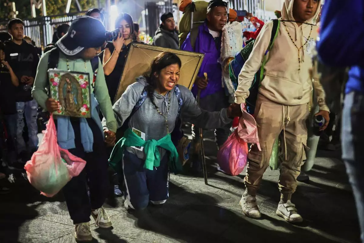 FILE - Pilgrims arrive at Our Lady of Guadalupe Basilica in Mexico City, Dec. 11, 2025, the night before her feast day. (AP Photo/Claudia Rosel, File)