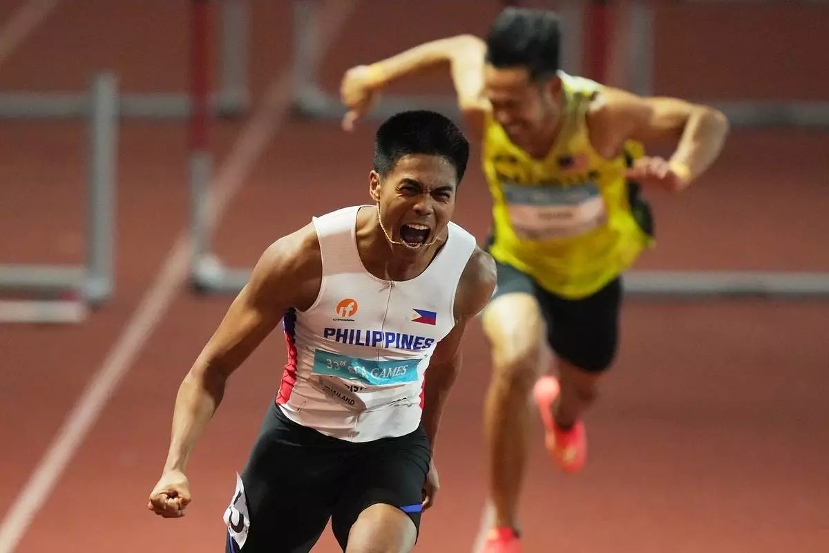 FILE - Philippines John Christopher Tolentino celebrates winning the men's 110m hurdles final race at the 33rd Southeast Asian Games in Bangkok, Thailand, Dec 12, 2025. (AP Photo/Achmad Ibrahim, File)