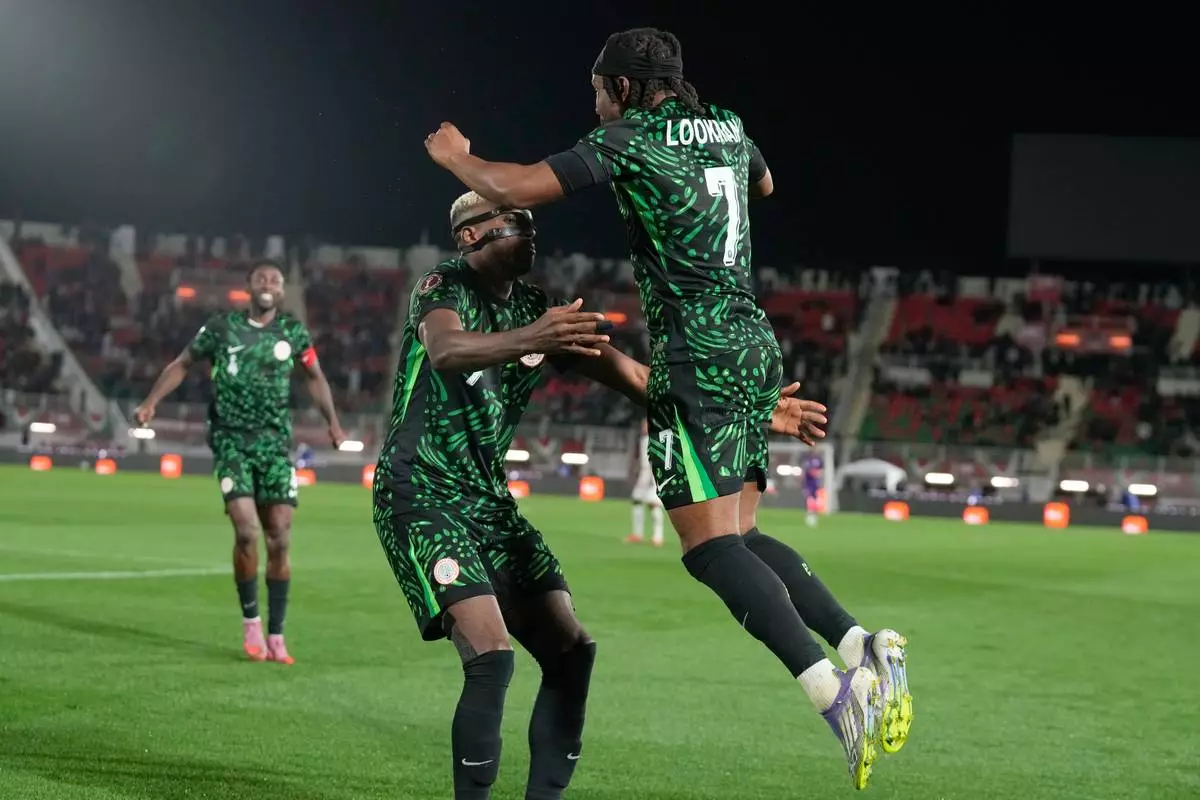 Nigeria's Victor Osimhen, center, celebrates with Nigeria's Ademola Lookman, right, after scoring his side's third goal during the Africa Cup of Nations round of 16 soccer match between Nigeria and Mozambique in Fez, Morocco, Monday, Jan. 5, 2026. (AP Photo/Themba Hadebe)