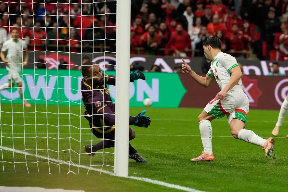 Morocco's Brahim Abdelkader Díaz, right, scores his side's opening goal during the Africa Cup of Nations quarterfinal soccer match between Cameroon and Morocco, in Rabat, Morocco, Friday, Jan. 9, 2026. (AP Photo/Mosa'ab Elshamy)