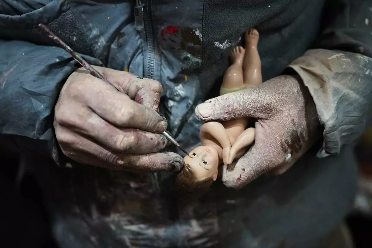 Adolfo Vertiz repairs a figurine of Baby Jesus ahead of "Día de la Candelaria," or Candlemas, in Mexico City, Thursday, Jan. 29, 2026. (AP Photo/Eduardo Verdugo)