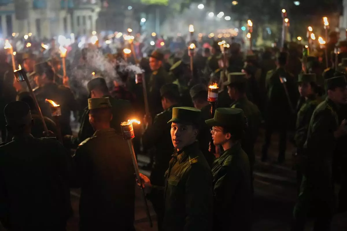 Soldiers march with torches to mark the 173rd anniversary of the birth of national independence hero Jose Marti, in Havana, Tuesday, Jan. 27, 2026. (AP Photo/Ramon Espinosa)