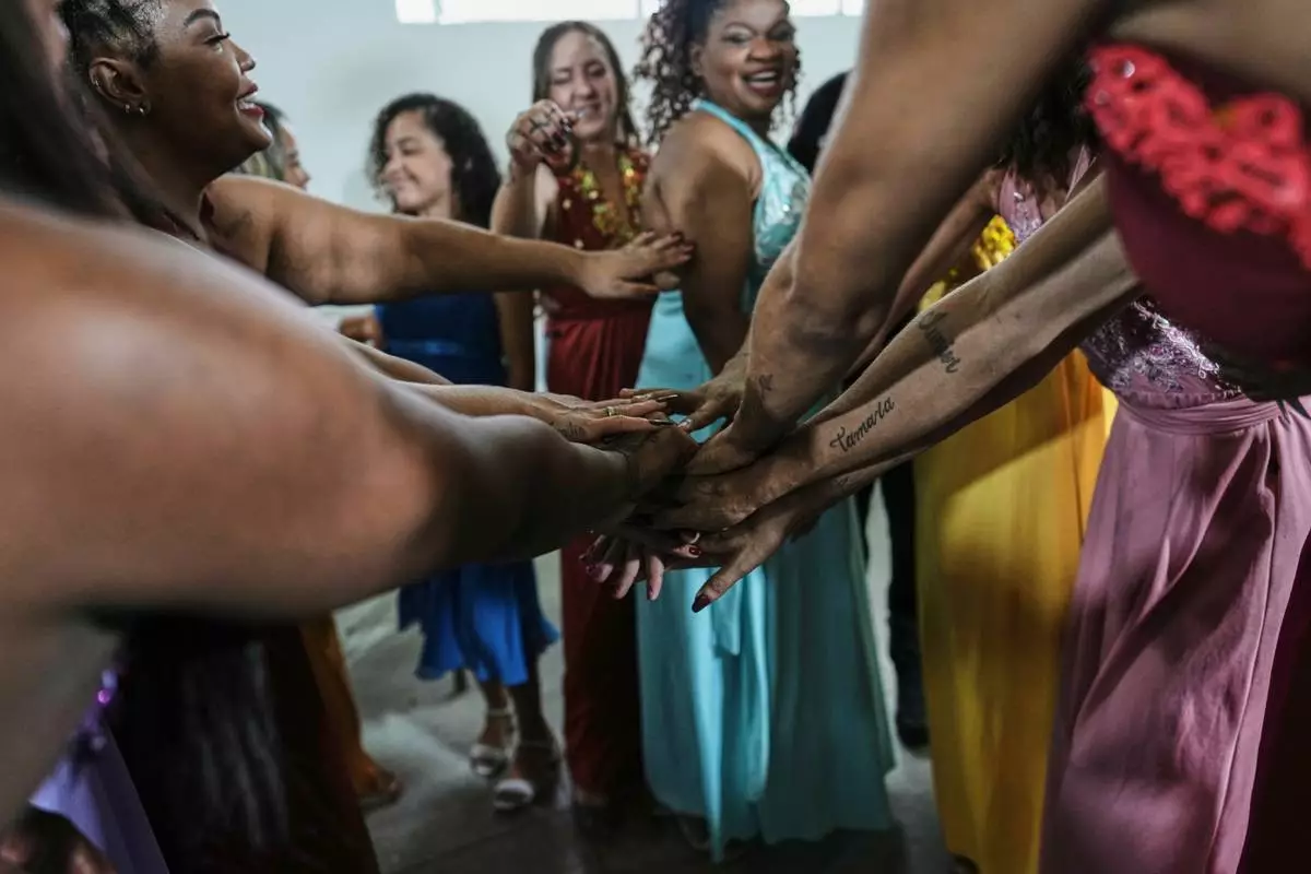Inmates wish each other good luck before competing in the Voice of Freedom rehabilitation program singing contest at the Djanira Dolores de Oliveira women's penitentiary in Rio de Janeiro, Friday, Jan. 23, 2026. (AP Photo/Silvia Izquierdo)