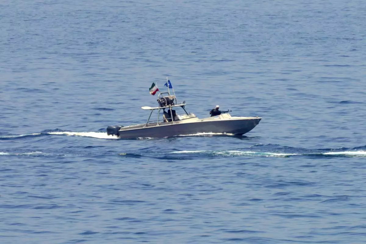 FILE - An Iranian Revolutionary Guard vessel watches an American warship in the Strait of Hormuz, May 19, 2023. (AP Photo/Jon Gambrell, File)
