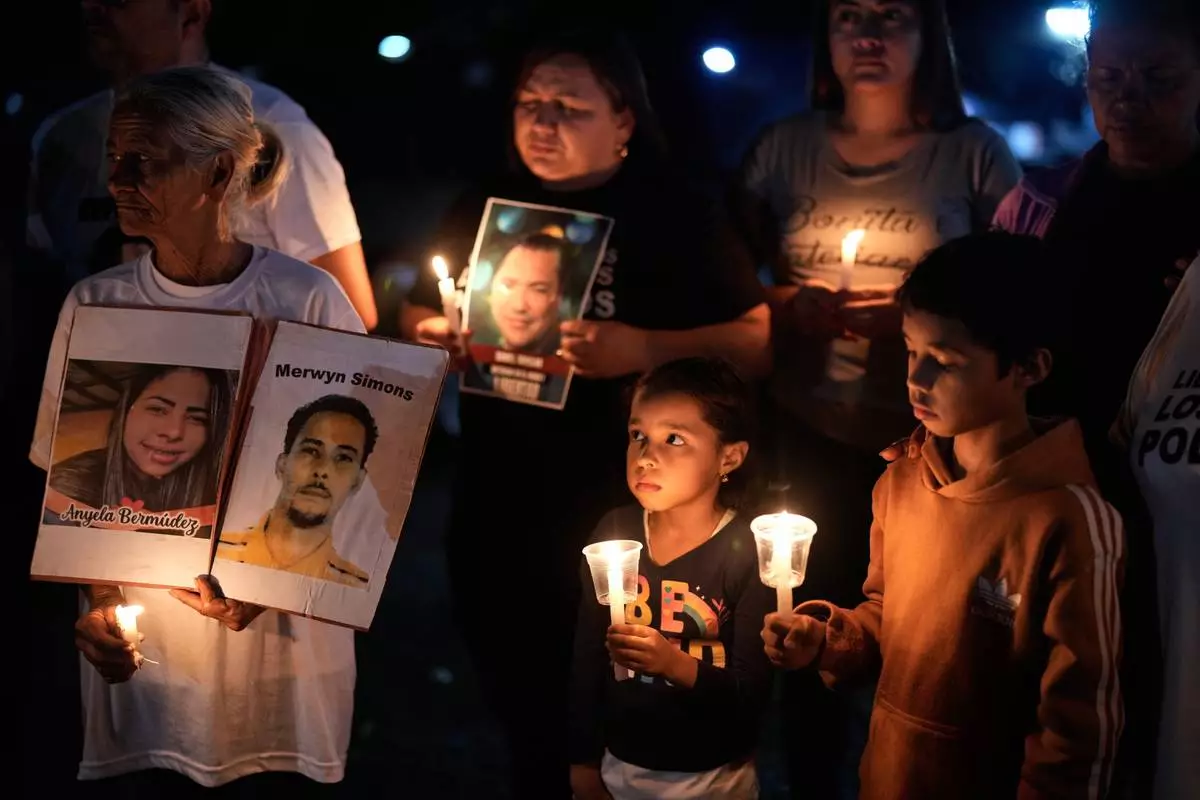 Relatives of people they consider political prisoners hold a vigil calling for the release of their loved ones outside the Rodeo I prison in Guatire, Venezuela, Friday, Jan. 23, 2026. (AP Photo/Ariana Cubillos)