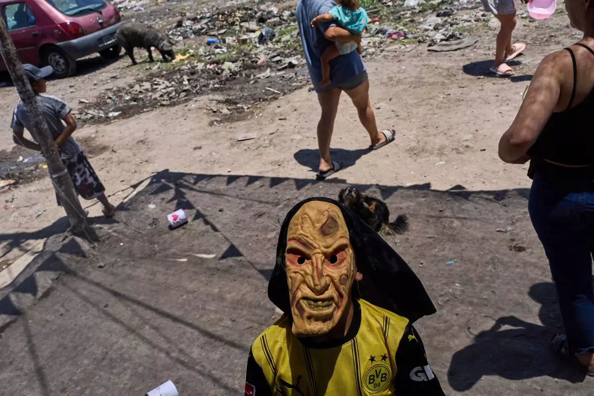 FILE - A boy wears a mask delivered by Santa Claus during a post-Christmas celebration for impoverished youth in Buenos Aires, Argentina, Dec. 27, 2025. (AP Photo/Rodrigo Abd, File)