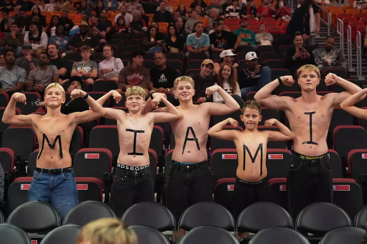 FILE - Fans pose for a photo before an NBA basketball game between the Miami Heat and the Indiana Pacers, Dec. 27, 2025, in Miami. (AP Photo/Lynne Sladky, File