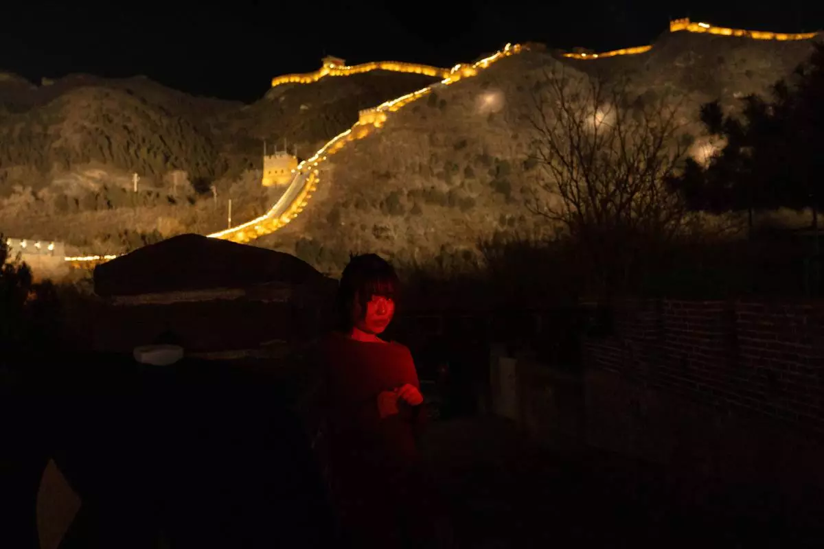FILE - A woman stands for a photo by her friend before an event to ring in the new year at the Juyongguan Great Wall on the outskirts of Beijing, Dec. 31, 2025. (AP Photo/Ng Han Guan, File)