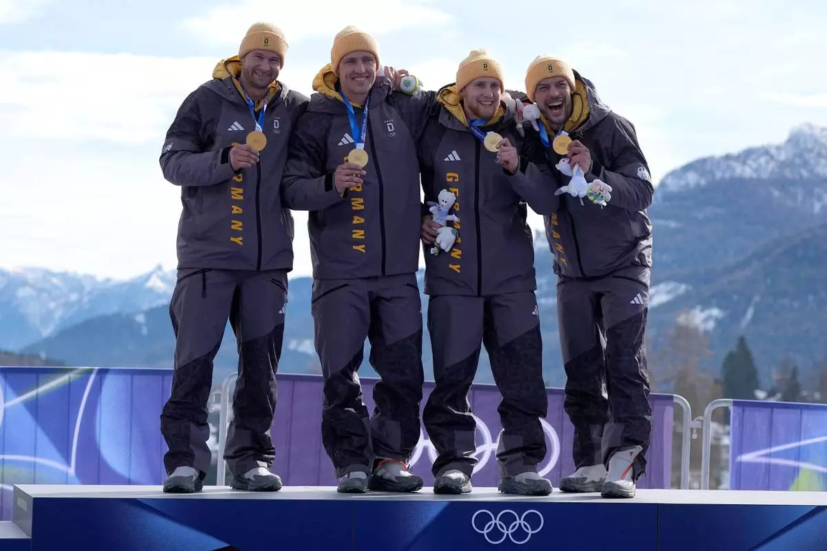 Germany's gold medalists Johannes Lochner, Thorsten Margis, Jorn Wenzel and Georg Fleischauer pose with their medals after the four man bobsled competition at the 2026 Winter Olympics, in Cortina d'Ampezzo, Italy, Sunday, Feb. 22, 2026.(AP Photo/Alessandra Tarantino)