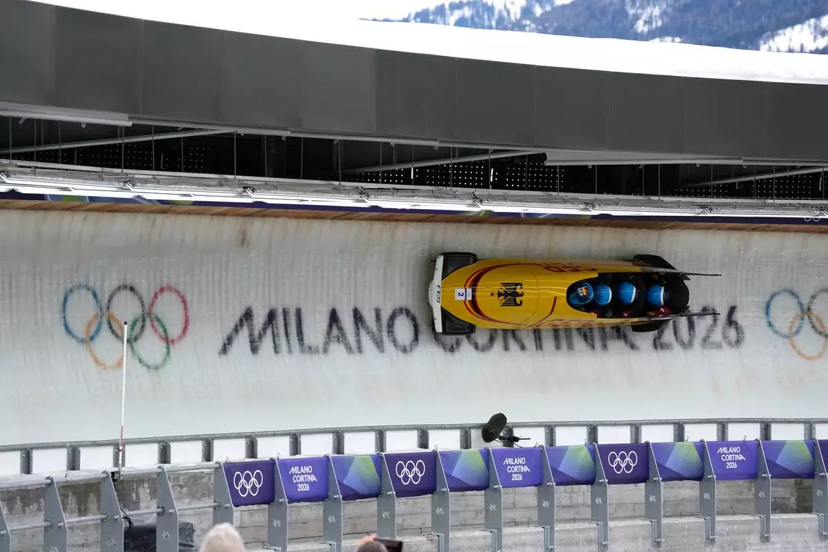 Germany's Francesco Friedrich, left, Matthias Sommer, Alexander Schuller and Felix Straub slide down the track during a four man bobsled run at the 2026 Winter Olympics, in Cortina d'Ampezzo, Italy, Sunday, Feb. 22, 2026. (AP Photo/Alessandra Tarantino)