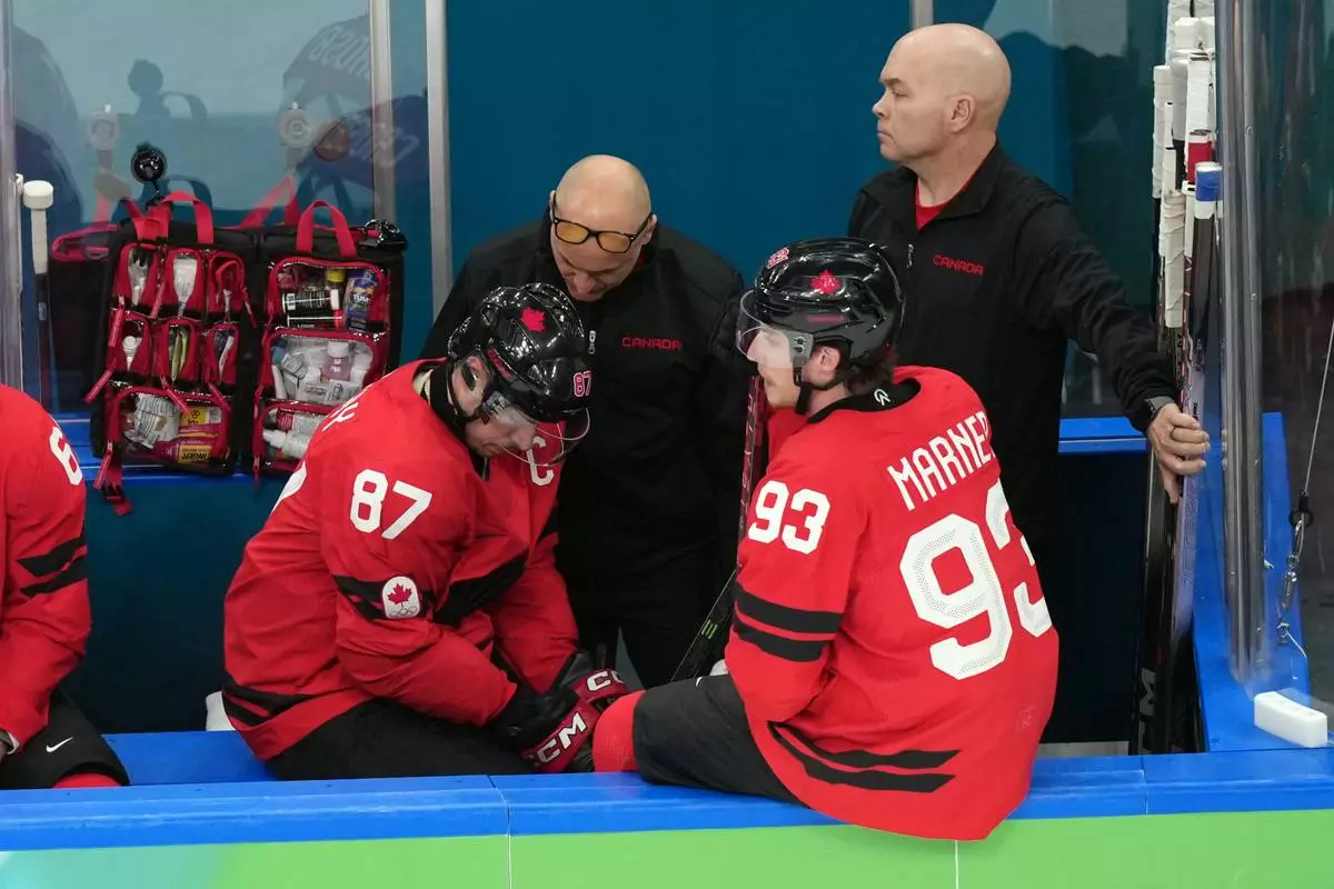 Canada's Sidney Crosby (87) is attended to after being injured during the second period of a men's ice hockey quarterfinal game between Canada and Czechia at the 2026 Winter Olympics, in Milan, Italy, Wednesday, Feb. 18, 2026. (AP Photo/Hassan Ammar)