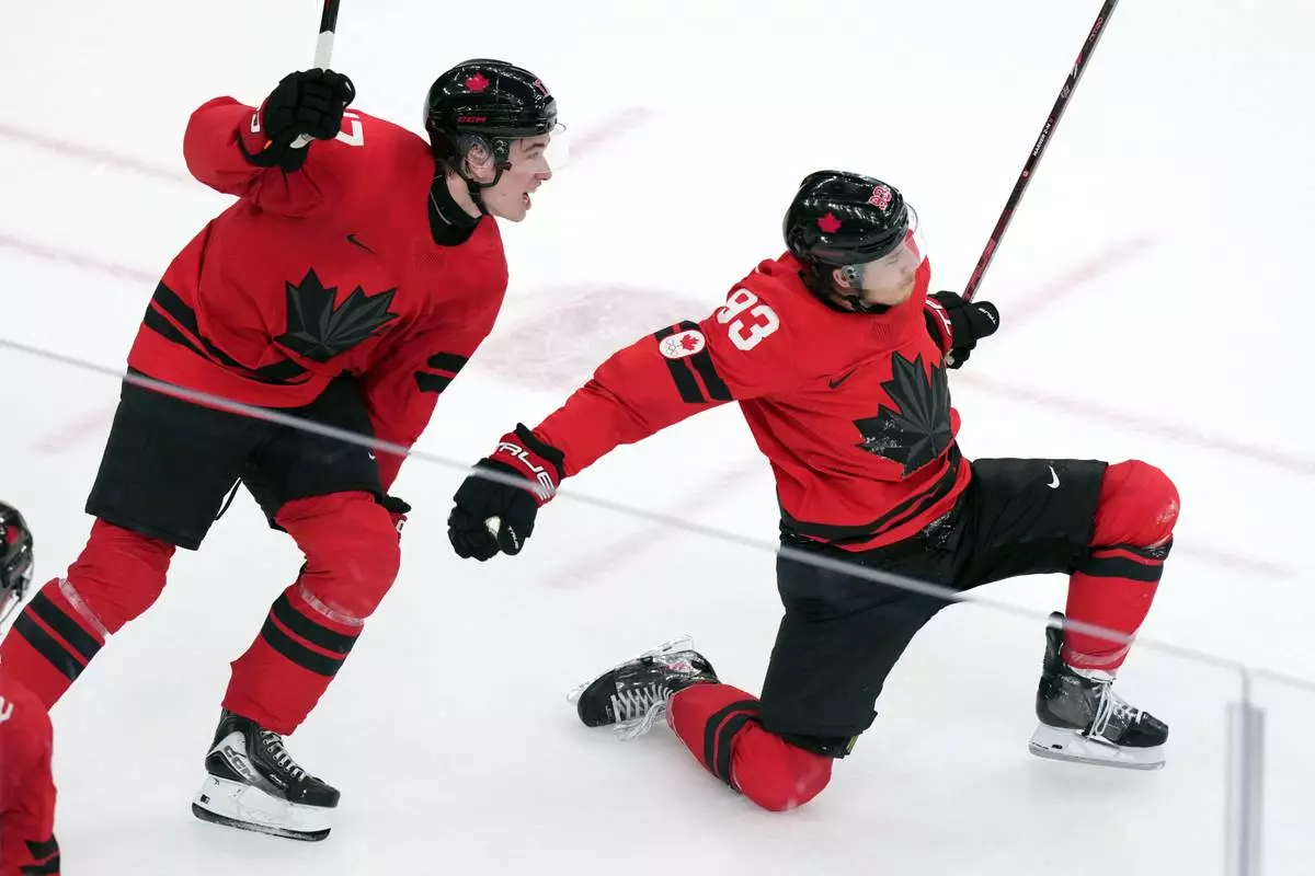 Canada's Mitch Marner (93) and Macklin Celebrini (17) celebrate after Marner scored the winning goal during the overtime period of a men's ice hockey quarterfinal game between Canada and Czechia at the 2026 Winter Olympics, in Milan, Italy, Wednesday, Feb. 18, 2026. (AP Photo/Carolyn Kaster)