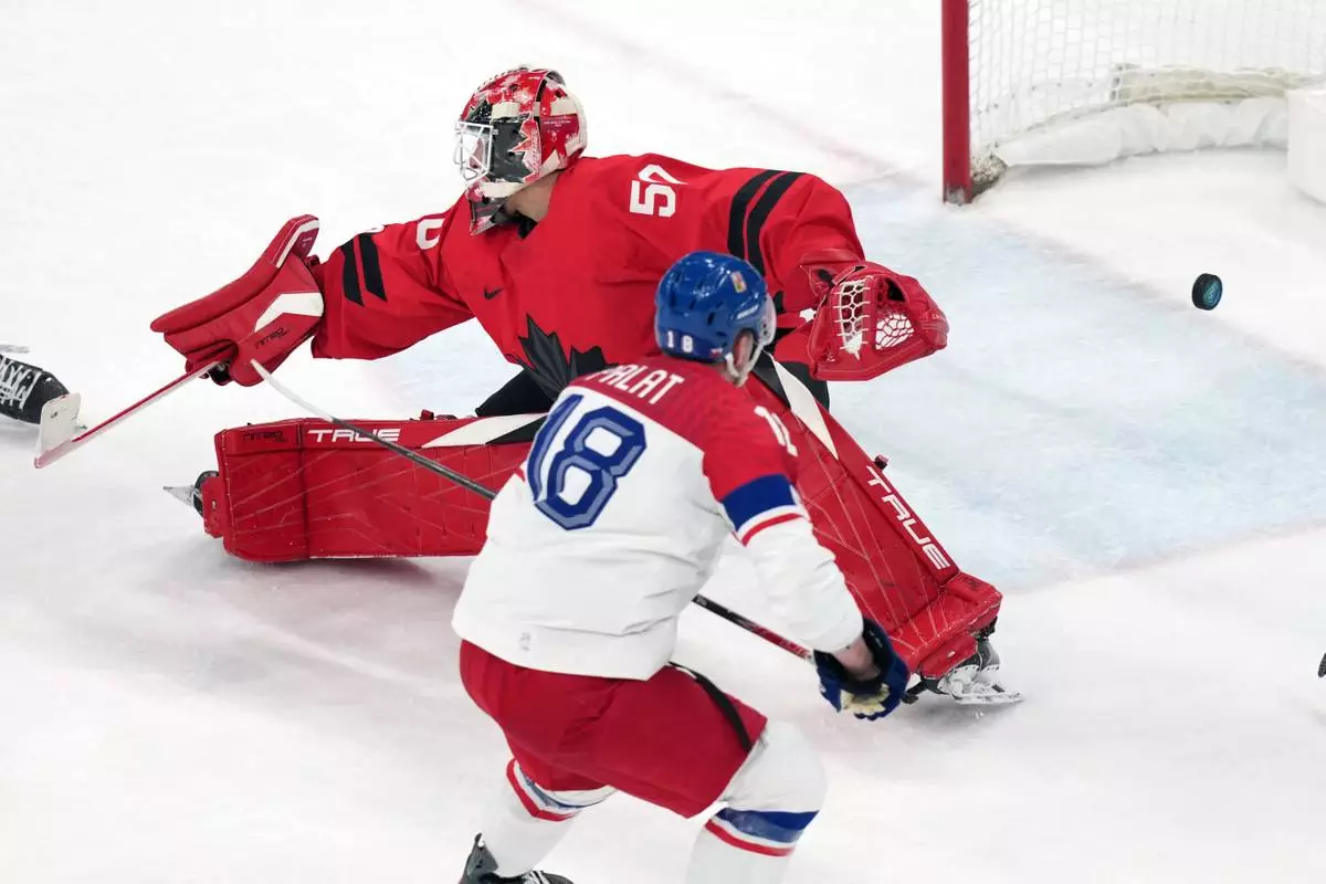 Czechia's Ondrej Palat (18) scores a goal against Canada goalkeeper Jordan Binnington (50) during the third period of a men's ice hockey quarterfinal game at the 2026 Winter Olympics, in Milan, Italy, Wednesday, Feb. 18, 2026. (AP Photo/Carolyn Kaster)