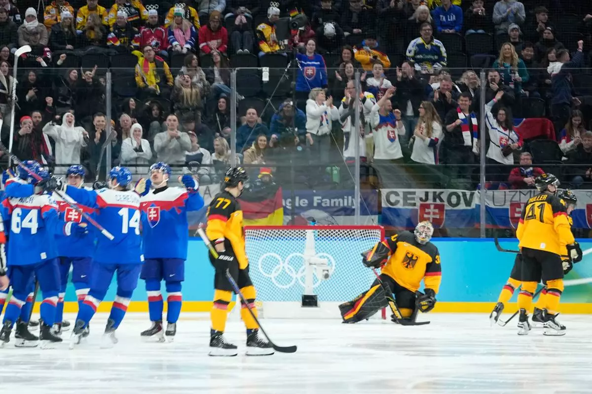 Germany players are dejected as Slovakia players celebrate their fifth goal during a men's ice hockey quarterfinal game between Slovakia and Germany at the 2026 Winter Olympics, in Milan, Italy, Wednesday, Feb. 18, 2026. (AP Photo/Petr David Josek)