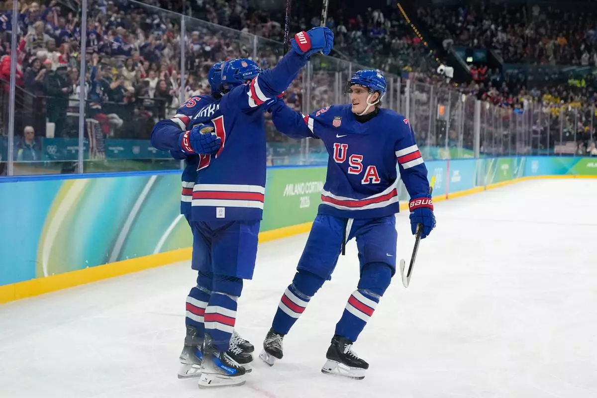 United States' Tage Thompson, right, celebrates with Dylan Larkin (21) after Larkin scored against Sweden during the second period of a men's ice hockey quarterfinal game at the 2026 Winter Olympics, in Milan, Italy, Wednesday, Feb. 18, 2026. (AP Photo/Hassan Ammar)