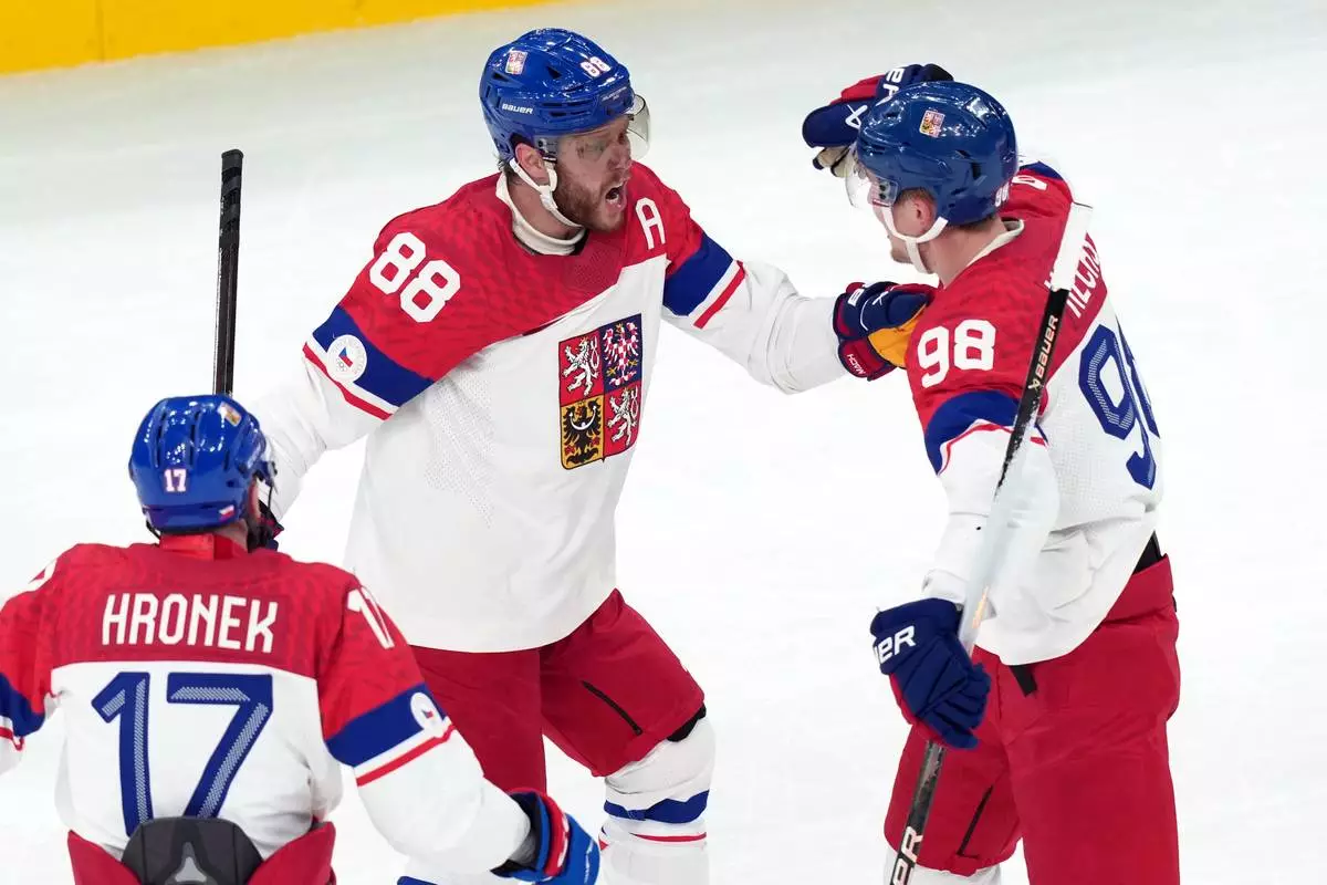 Czechia's David Pastrnak (88) celebrates with Martin Necas (98) and Filip Hronek (17) after Pastrnak scored a goal against Canada during the first period of a men's ice hockey quarterfinal game at the 2026 Winter Olympics, in Milan, Italy, Wednesday, Feb. 18, 2026. (AP Photo/Carolyn Kaster)