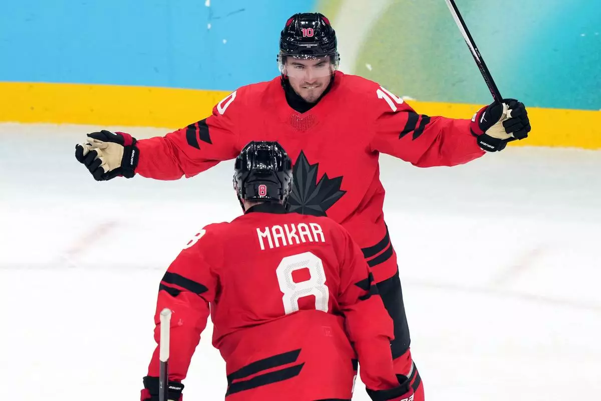 Canada's Nick Suzuki (10) celebrates with Cale Makar (8) after Suzuki scored a goal against Czechia during the third period of a men's ice hockey quarterfinal game at the 2026 Winter Olympics, in Milan, Italy, Wednesday, Feb. 18, 2026. (AP Photo/Carolyn Kaster)