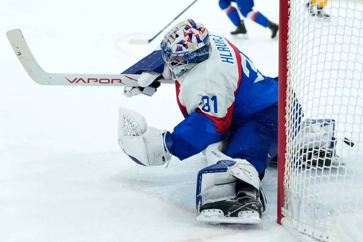 Slovakia's Samuel Hlavaj (31) fails to save a shot by Germany's Frederik Tiffels who's scored his side's second goal during a men's ice hockey quarterfinal game between Slovakia and Germany at the 2026 Winter Olympics, in Milan, Italy, Wednesday, Feb. 18, 2026. (AP Photo/Petr David Josek)