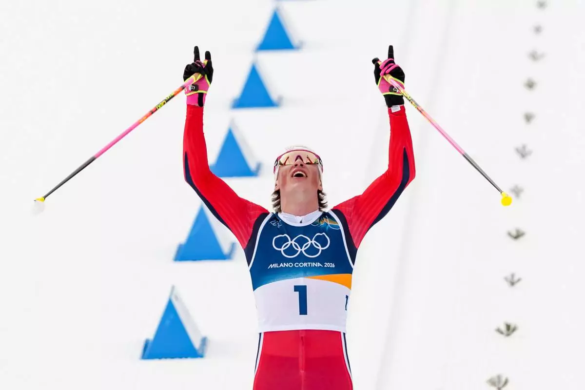 Johannes Hoesflot Klaebo, of Norway, crosses the finish line to win the gold medal during the cross country skiing men's 50km mass start Classic at the 2026 Winter Olympics, in Tesero, Italy, Saturday, Feb. 21, 2026. (AP Photo/Kirsty Wigglesworth)