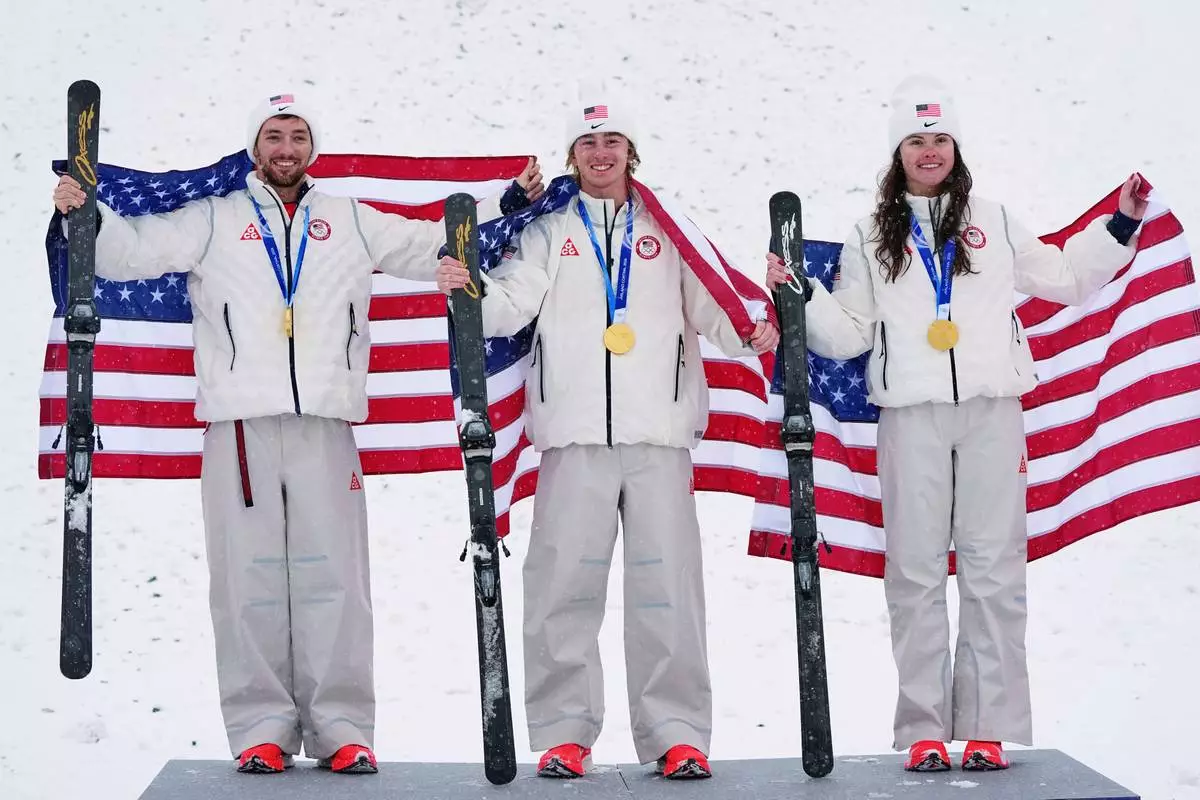Gold medalists United States' Christopher Lillis, Connor Curran and Kaila Kuhn celebrate after the freestyle skiing mixed team aerials final at the 2026 Winter Olympics, in Livigno, Italy, Saturday, Feb. 21, 2026. (AP Photo/Gregory Bull)
